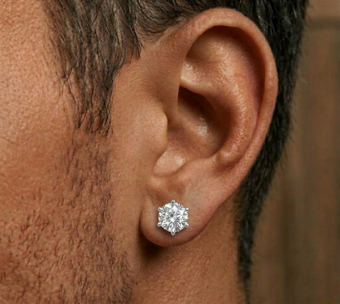 Round clear-stone stud earring worn on an ear