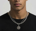 Layered silver tone compass pendant and curb chain necklaces worn together