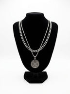 Layered silver tone compass necklace set on a black jewellery bust