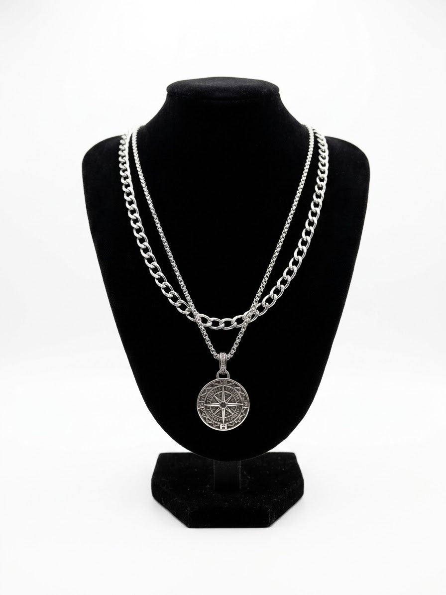 Layered silver tone compass necklace set on a black jewellery bust