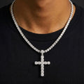 Silver tone clear-stone cross pendant and tennis chain worn over a black top