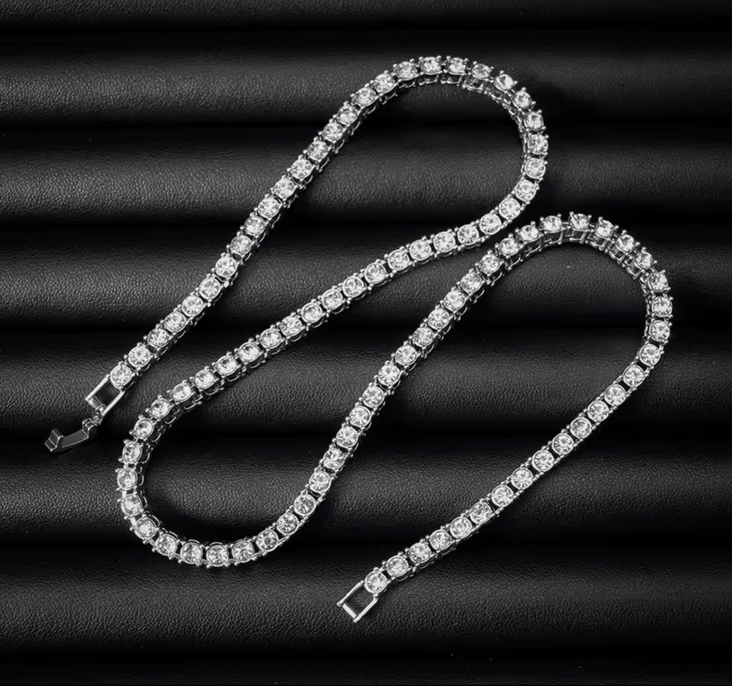 Silver tone tennis chain necklace laid out on black fabric