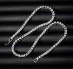 Silver tone tennis chain necklace laid out on black fabric