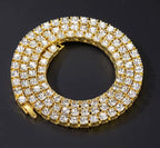 Close-up of a gold tone clear-stone tennis chain arranged in a coil