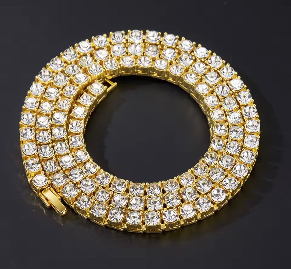 Close-up of a gold tone clear-stone tennis chain arranged in a coil