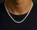 Gold tone tennis chain necklace with clear stones worn over a black top