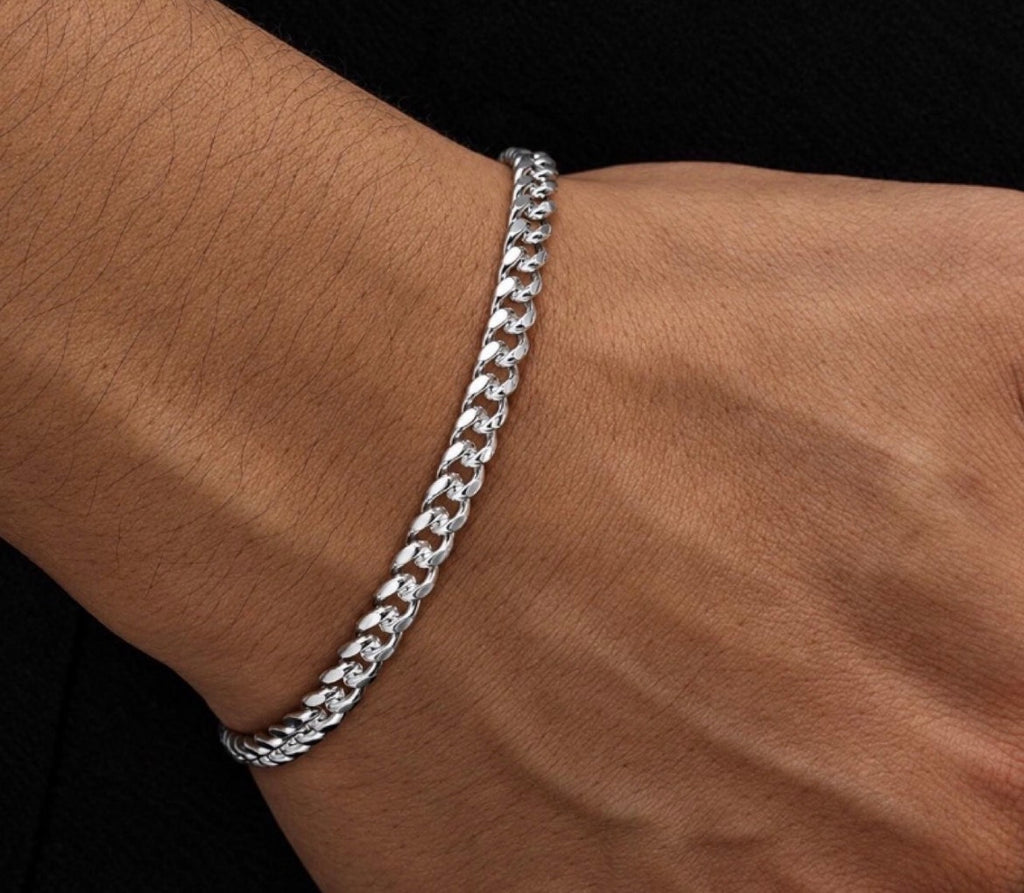 Silver tone link bracelet shown across the wrist