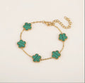 Gold tone bracelet with five green clover charms and an extender chain