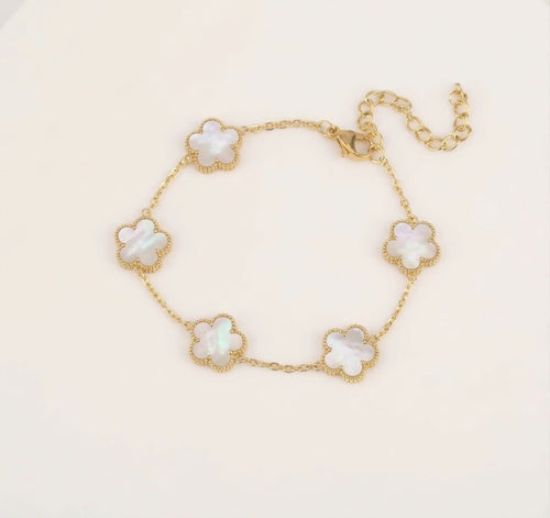 Gold tone bracelet with five white clover charms and an extender chain