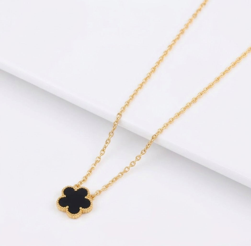 Black clover pendant with beaded edging on a gold tone chain