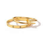Gold tone nail-inspired bangle and stone-detail bangle on a white background