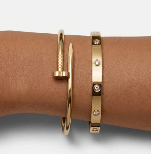 Gold tone nail-inspired and stone-detail bangles worn together